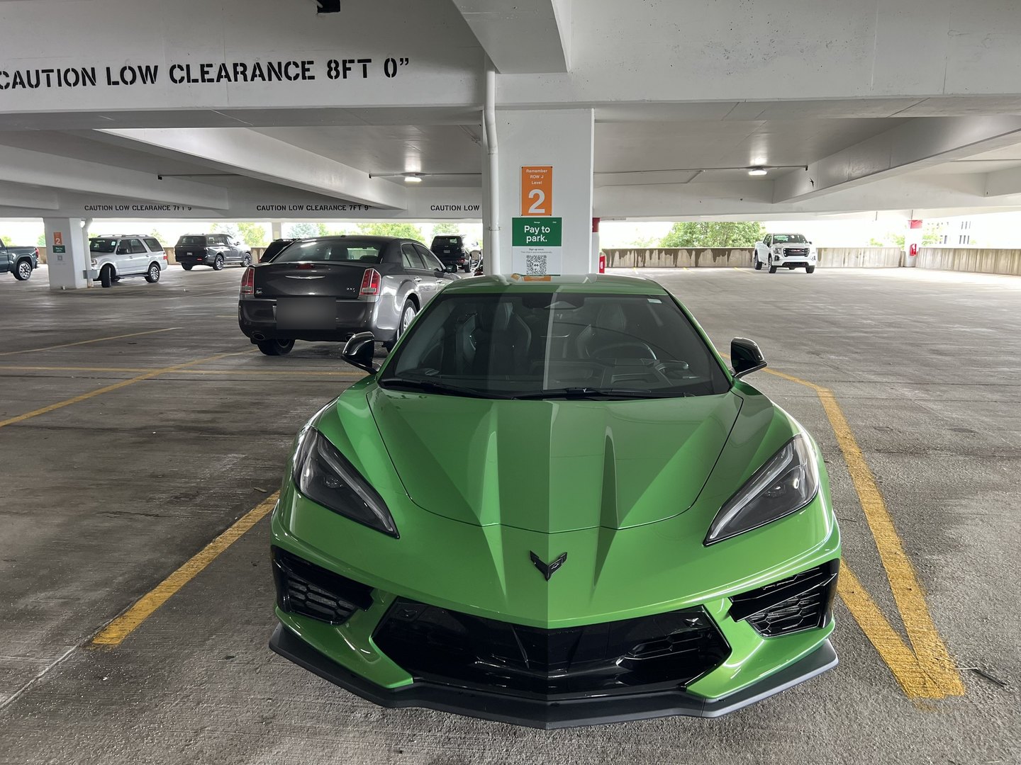 2026 Corvette Stingray parked head-on on level 2 of an airport parking garage