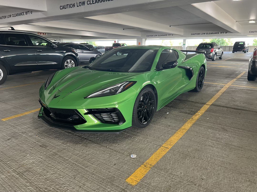 Green C8 Corvette Stingray waiting in an airport parking garage