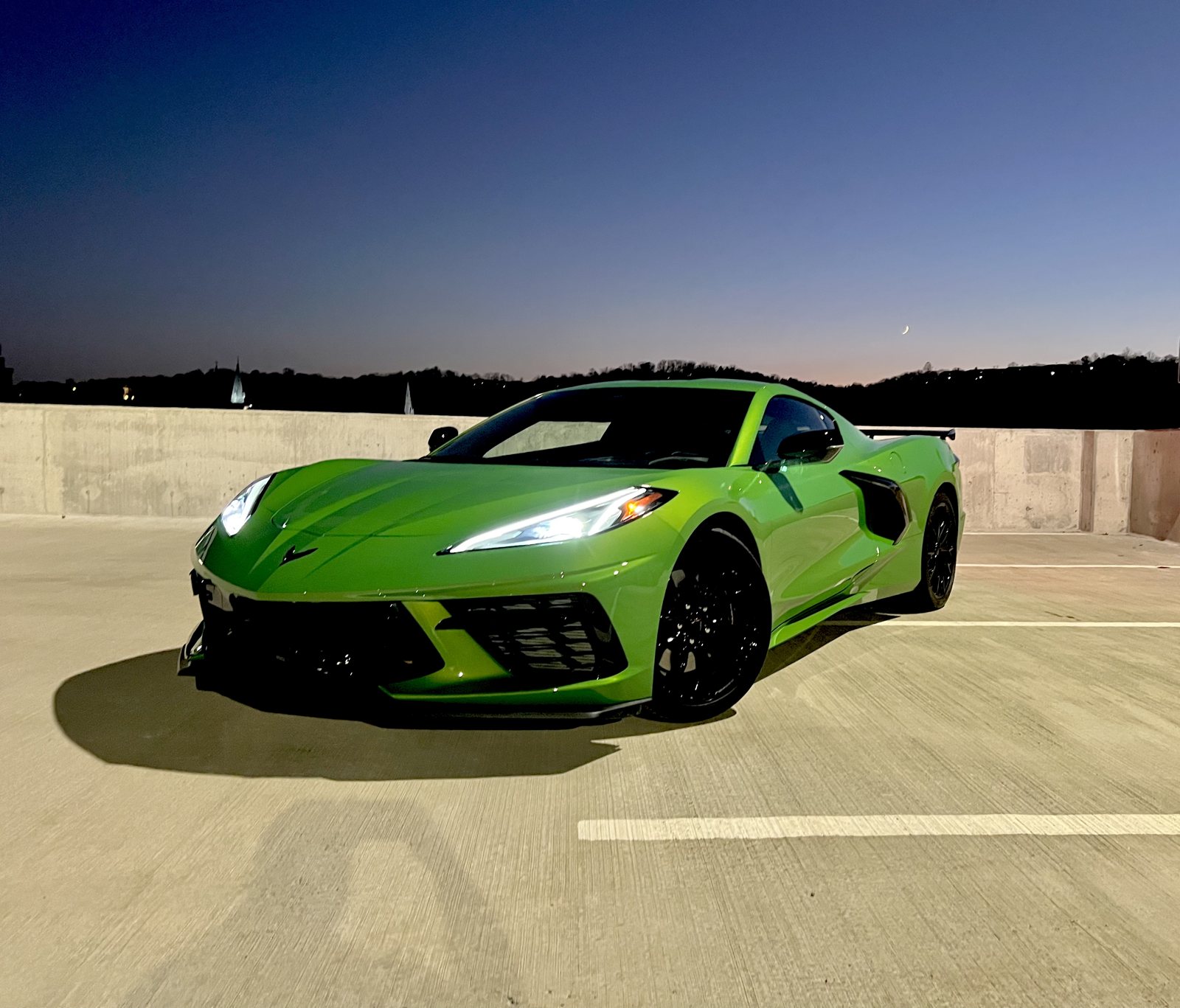 Green 2026 Chevrolet Corvette Stingray at dusk on a parking deck in Kentucky